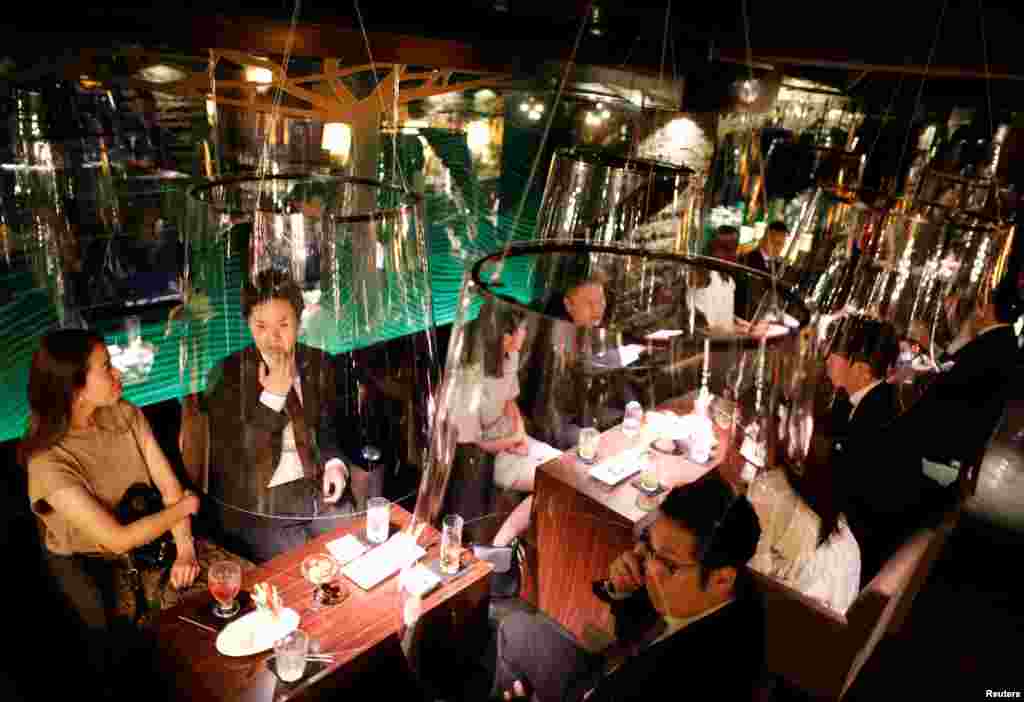 Goldfish bowl-like acrylic screens used as part of new social distancing measures and prevention of infection against the COVID-19 are installed at Jazz Lounge Encounter, a night club for seeking encounters, at Ginza district in Tokyo, Japan.