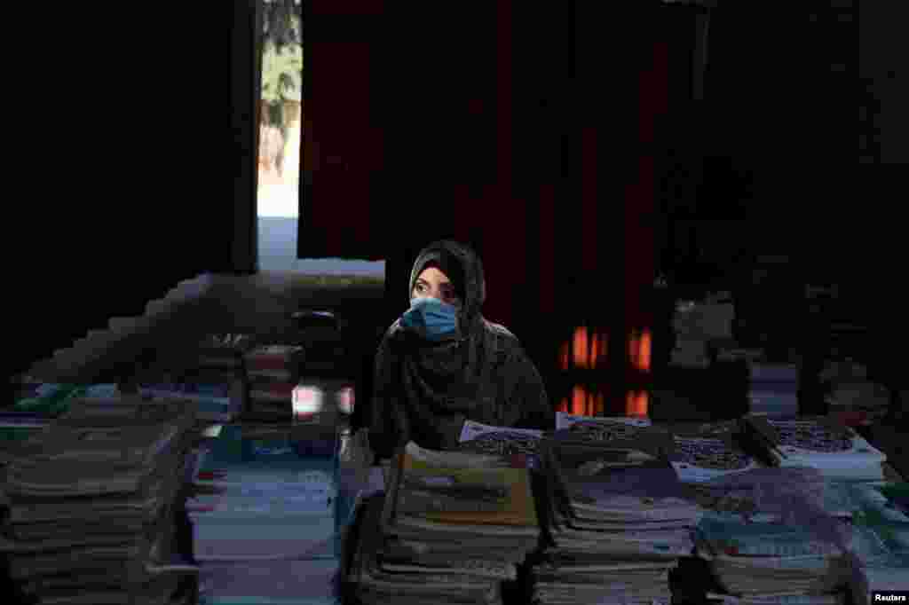 A Palestinian teacher waits to hand out books to students at a school as part of preparations by the Ministry of Education to reopen schools amid the COVID-19 outbreak, in the northern Gaza Strip.