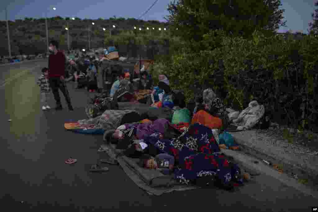 Migrants sleep on the road near the Moria refugee camp on the northeastern island of Lesbos, Greece after a second fire in the camp destroyed nearly everything.