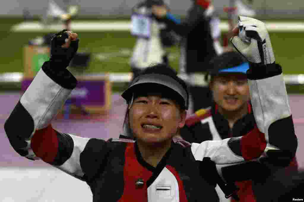 Dịch Tư Linh của Trung Quốc phản ứng sau khi đoạt huy chương vàng đầu tiên của Olympics trong môn súng trường hơi 10 mét nữ, 28/7/2012.