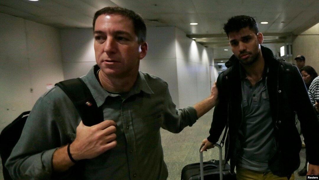 U.S. journalist Glenn Greenwald (L) walks with his partner David Miranda in Rio de Janeiro's International Airport, August 19, 2013. 