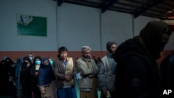Orang-orang mengantre untuk menerima uang tunai pada pembagian uang yang diselenggarakan oleh Program Pangan Dunia di Kabul, Afghanistan, 3 November 2021. (Foto: AP)