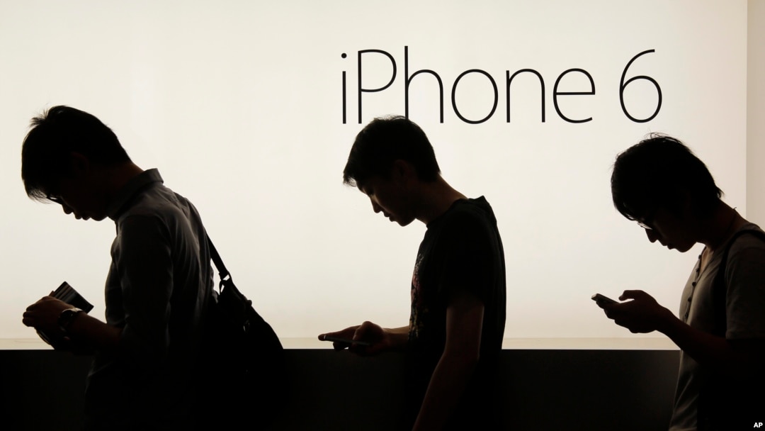 File - People wait to buy the Apple iPhone 6 and 6 Plus devices outside an Apple store in Hong Kong, Sept. 19, 2014.