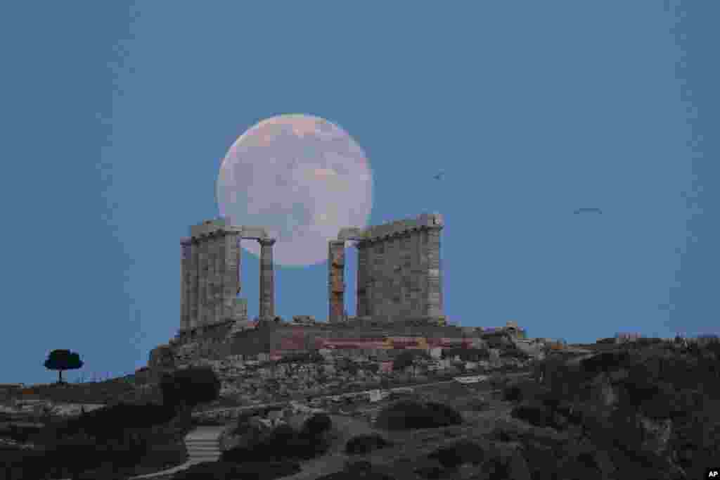 Bulan purnama menjadi latar belakang Kuil Poseidon di Cape Sounion, Athena tenggara, pada malam summer solstice atau hari terpanjang di musim panas, 20 Juni 2016.