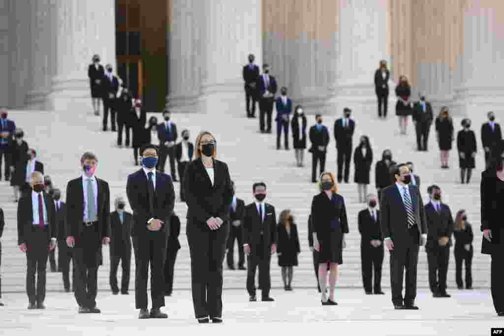 People wait for the casket of the late Supreme Court Justice Ruth Bader Ginsburg to arrive at the U.S. Supreme Court in Washington.