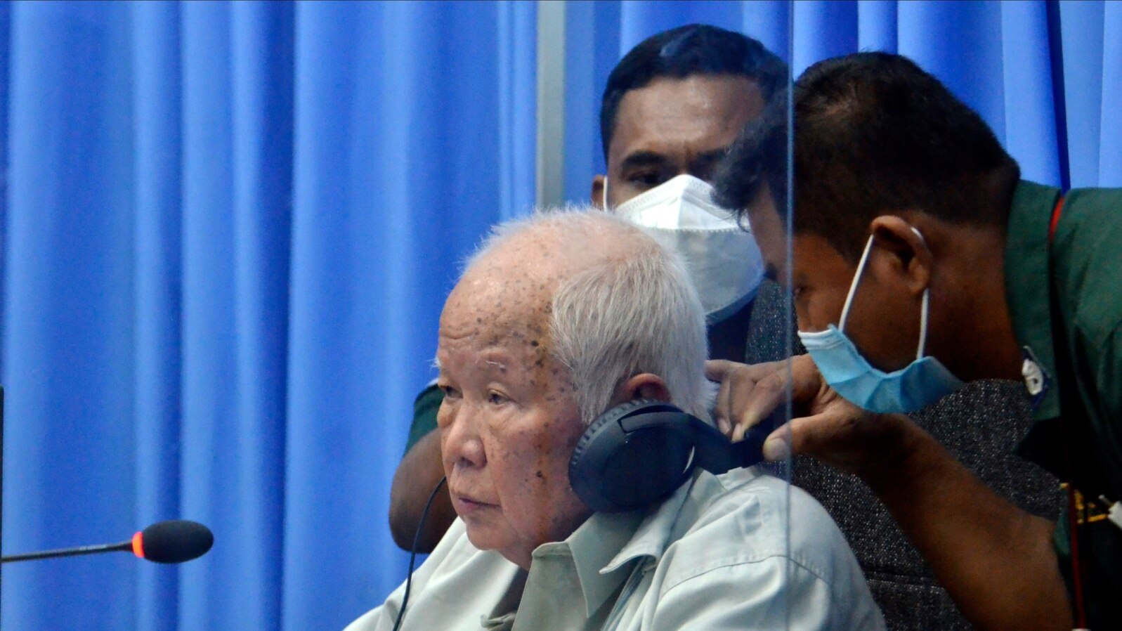 Khieu Samphan, left, the former head of state for the Khmer Rouge, sits in a courtroom during a hearing at the U.N.-backed war crimes tribunal in Phnom Penh, Cambodia, Aug. 19, 2021.