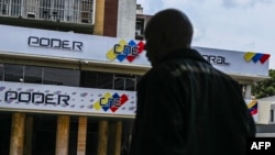 Un hombre camina frente a un punto de actualización de datos de votantes del CNE venezolano, en Caracas, el pasado 16 de abril de 2024.