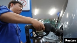 Một nhân viên bơm xăng vào ô tô tại một cây xăng ở Hà Nội (ảnh tư liệu, 20/12/2016, REUTERS/Kham).