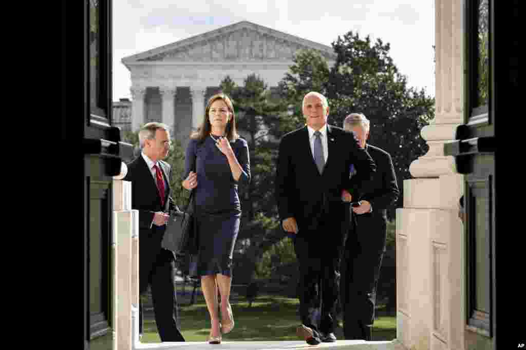 Judge Amy Coney Barrett, President Donald Trump's nominee to the Supreme Court, left, and Vice President Mike Pence arrive at the Capitol where she will meet with Senators in Washington, D.C.