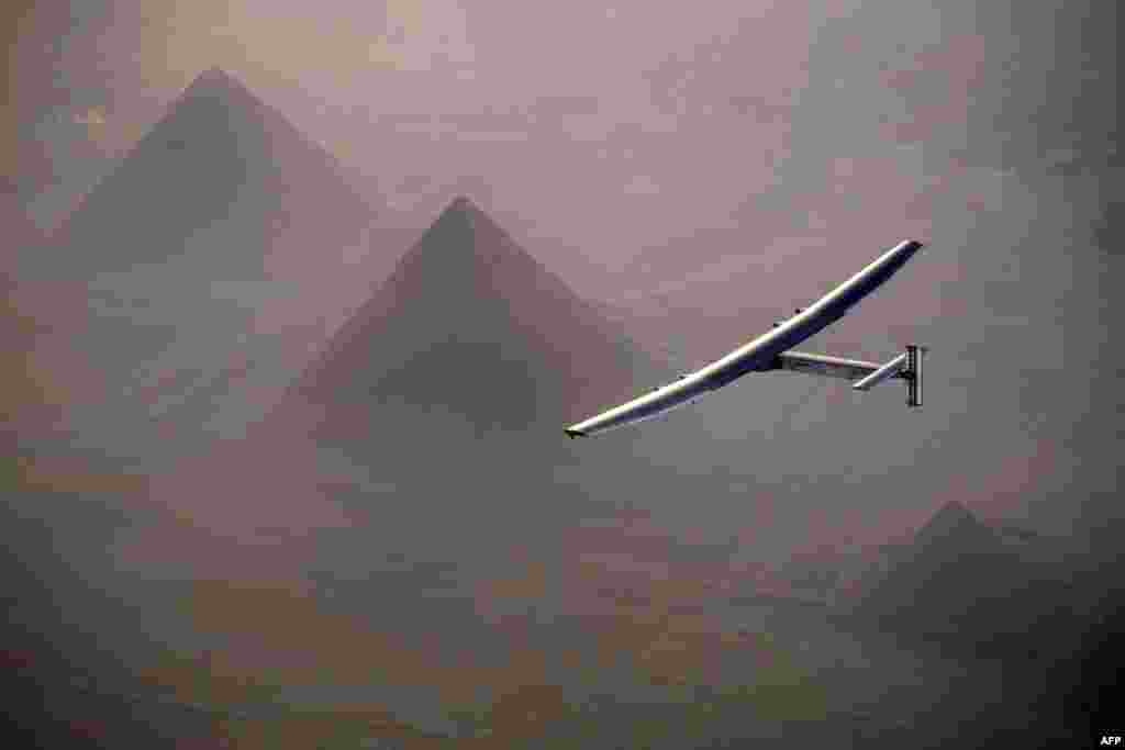 Pesawat tenaga surya Solar Impulse 2 terbang di atas bangunan piramid di Giza, sebelum mendarat di Kairo, Mesir.