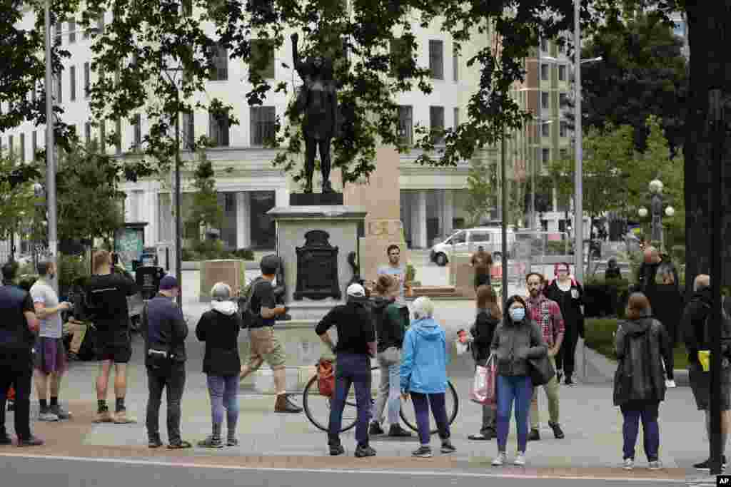 People look at a statue of a Black Lives Matter protester by British artist Marc Quinn erected in the spot once occupied by the statue of a slave trader in the English city of Bristol. 