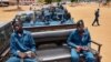 FILE - Police officers sit on the back of pickup trucks as they prepare to patrol the streets of Juba, South Sudan, April 9, 2020. A new U.N. report accuses the country's government and security forces of gross violations.