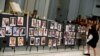 A woman places a photograph of one of the victims in the shooting at the Pulse gay nightclub, on a memorial during an Interfaith Service at First United Methodist Church in Orlando, Florida, June 14, 2016.