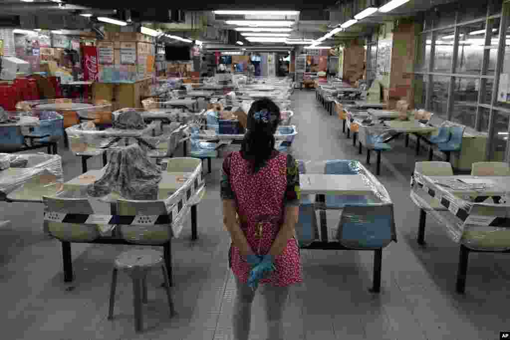 A restaurant employee looks at empty tables at a Chinese food court in Hong Kong. Hong Kong has banned dining-in at restaurants completely as the city battles its worst coronavirus outbreak to date.