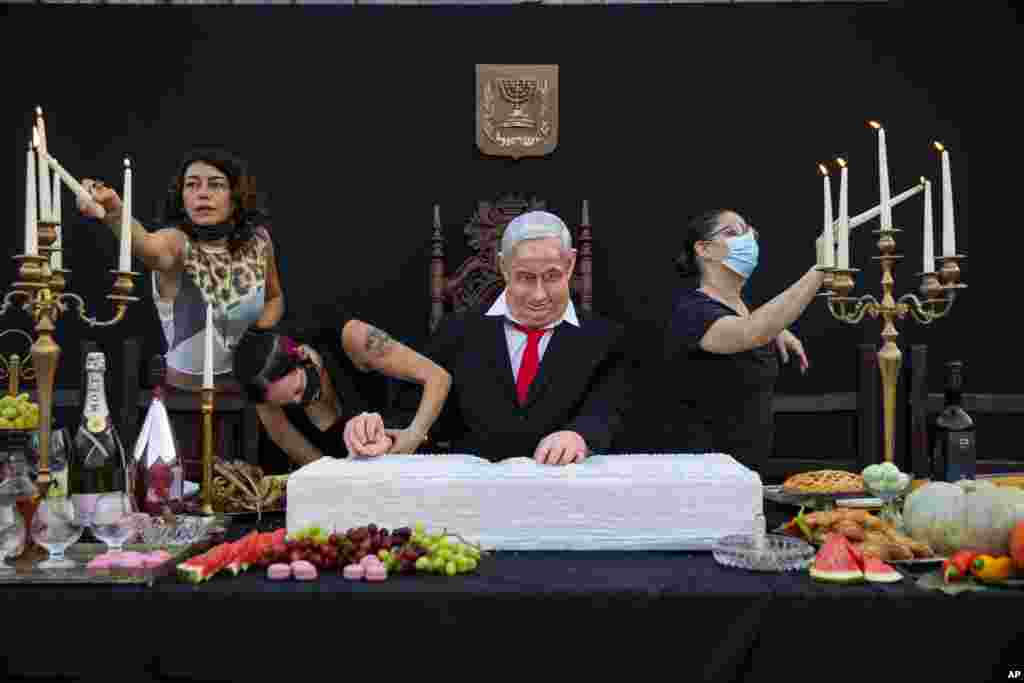 Team members of Israeli artist Itay Zalait work on an installation depicting Prime Minister Benjamin Netanyahu at a mock "Last Supper" at Rabin square in Tel Aviv.