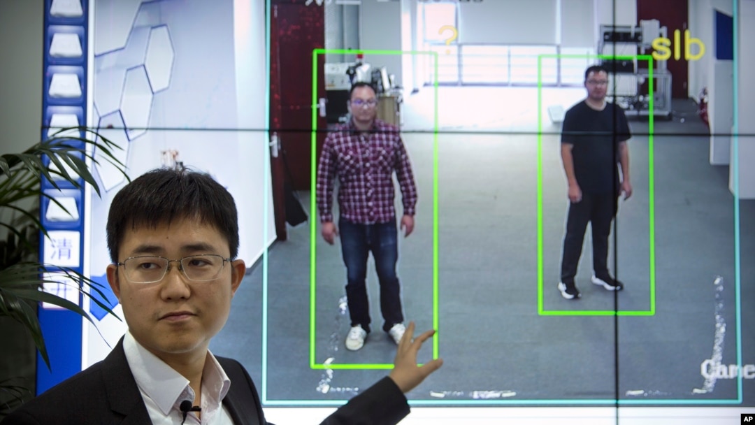 In this Oct. 31, 2018, photo, Huang Yongzhen, CEO of Watrix, demonstrates the use of his firm's gait recognition software at his company's offices in Beijing. 