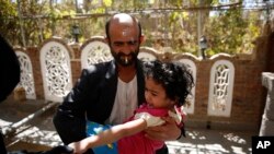 FILE - A Yemeni health worker marks a finger of a girl after giving her a polio vaccination.