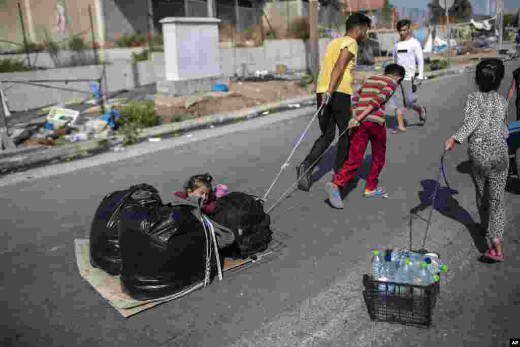 Migrants pull a child and their belongings in Kara Tepe, near Mytilene the capital of the northeastern island of Lesbos, Greece.