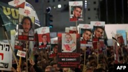 Demonstranti u Tel Avivu drže transparente sa fotografijama izraelskih talaca (Foto: AHMAD GHARABLI / AFP)