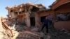 A Christian man inspects his neighbors' home, destroyed by Islamic State militants in the Christian city of Qaraqosh, Iraq, Sept. 12, 2018.