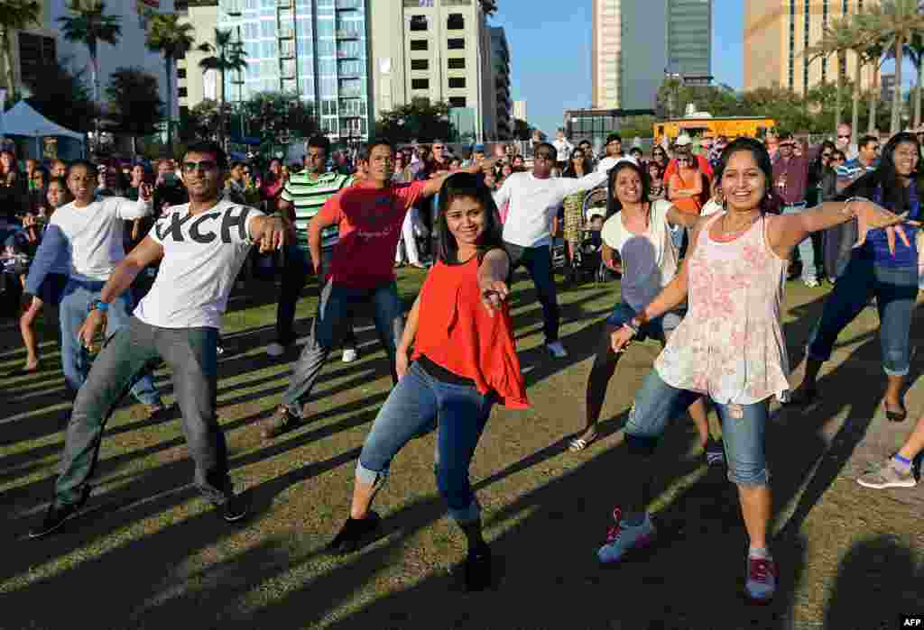 Para pengunjung, sebagian besar warga AS keturunan India, berjoget bersama pada pembukaan Festival Film Internasional India di Taman Curtis Hixon di kota Tampa, Florida, AS.