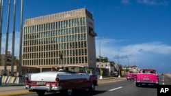 ARCHIVO - Turistas viajan en autos convertibles clásicos en el Malecón junto a la Embajada de Estados Unidos en La Habana, Cuba, el 3 de octubre de 2017.