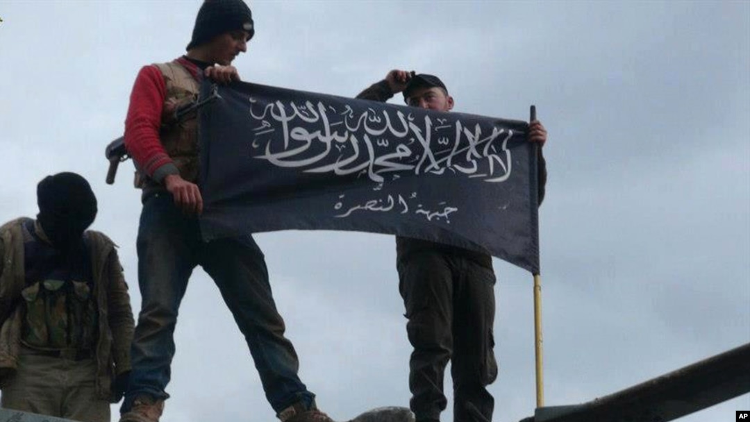 FILE - Rebels from al-Qaida affiliated Jabhat al-Nusra waving their brigade flag.
