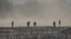 ARCHIVO: Un grupo de migrantes es detenido por miembros de la Guardia Nacional de Estados Unidos en Eagle Pass, Texas, visto desde Piedras Negras, México, el 4 de febrero de 2024.