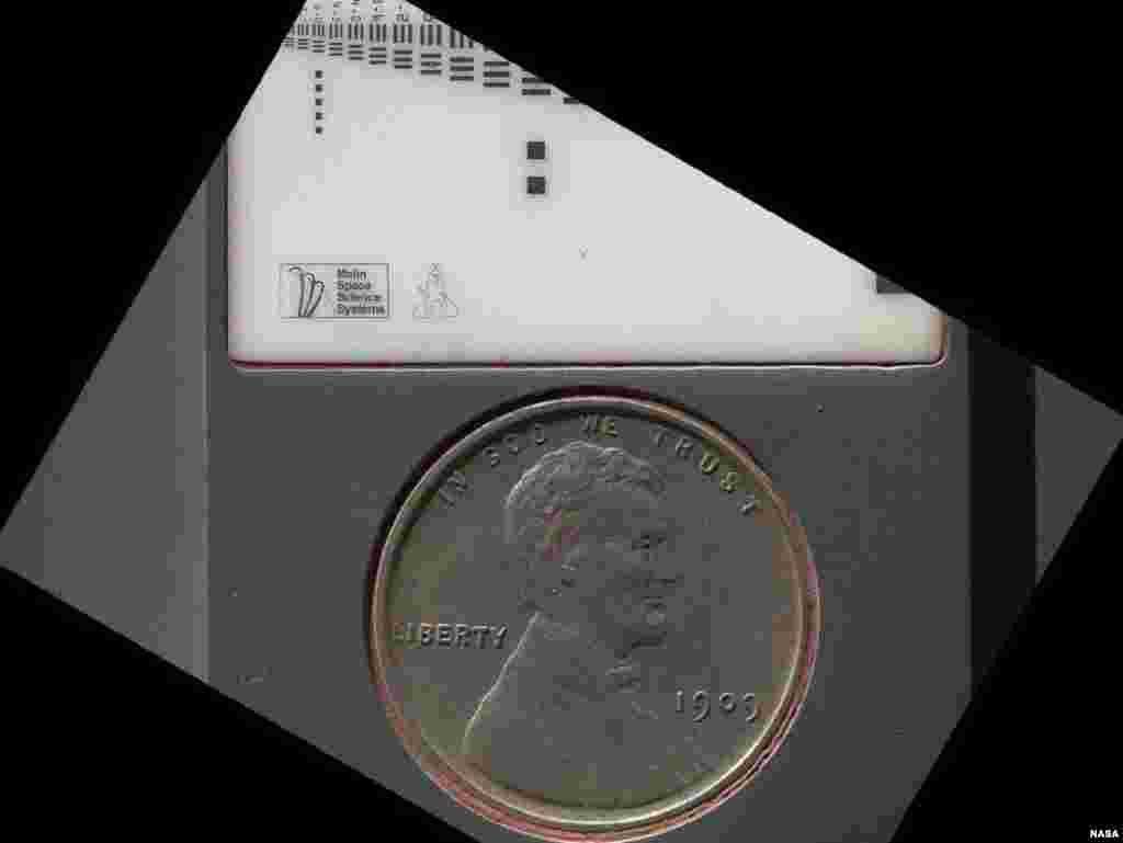 A penny that is used by Curiosity to calibrate its Mars Hand Lens Imager camera. The penny is covered in Martian dust, September 9, 2012.