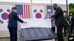 한국의 문재인 대통령이 21일 저녁 미한 정상회담 공동 기자회견 뒤 한국전 참전용사 기념공원에서 열린 추모의 벽 착공식에 참석해 로이드 오스틴 미 국방장관과 함께 명판을 가리고 있던 현수막을 걷어 냈다. 