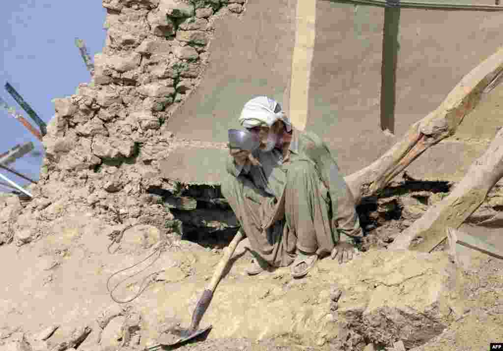 Seorang korban gempa bumi di Pakistan melepaskan dahaganya di rumahnya yang runtuh di daerah Dhall Bedi Peerander, distrik Awaran, yang hancur akibat gempa. Puluhan ribu korban gempa menunggu bantuan seiring dengan meningkatnya jumlah korban tewas mencapai hampir 350 jiwa.