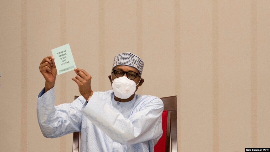 Rais wa Nigeria Muhamamadu Buhari akionyesha cheti cha chanjo ya corona.