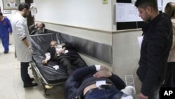 En esta foto divulgada por la agencia oficial de noticias siria SANA, hombres sirios heridos esperan recibir tratamiento médico después de ser heridos en un ataque suicida en Damasco, Siria, el miércoles, 15 de marzo, de 2017.