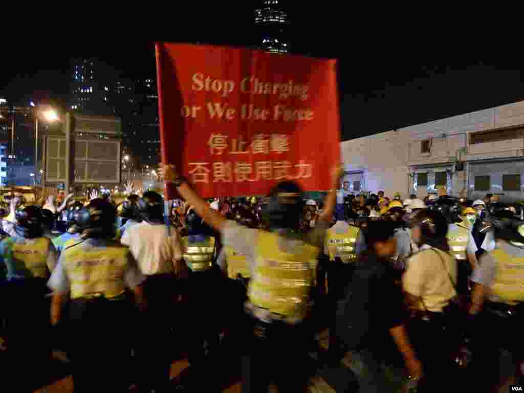 大批防穿上防暴裝備的警員高舉警告標語,驅散佔領龍和道的示威者