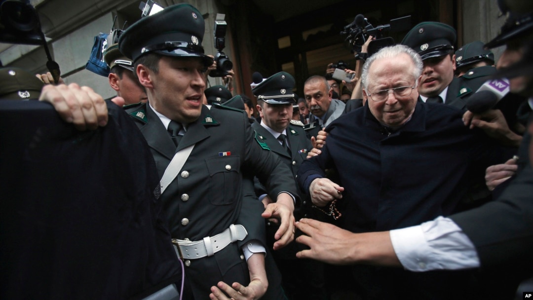FILE - The Rev. Fernando Karadima, center, is escorted from court after testifying in a lawsuit brought by three of his victims alleging sex abuse cover-up by the Archdiocese of Santiago, Nov. 11, 2015. 