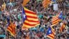 Manifestantes agitan banderas separatistas catalanas durante una manifestación organizada por los movimientos independentistas catalanes, tras el encarcelamiento de sus dos líderes Jordi Sánchez y Jordi Cuixart, en Barcelona, el 21 de octubre de 2017.