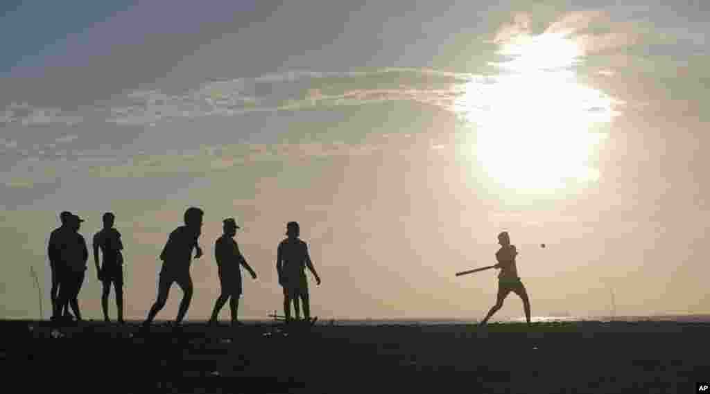 Sri Lankan youths play a pick up game of "Elle", a local game similar to base ball, on the sea promenade in Colombo.