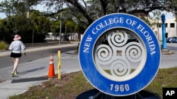 FILE - A student makes her way past the sign at New College of Florida, Jan. 20, 2023, in Sarasota, Fla. (AP Photo/Chris O'Meara, File)