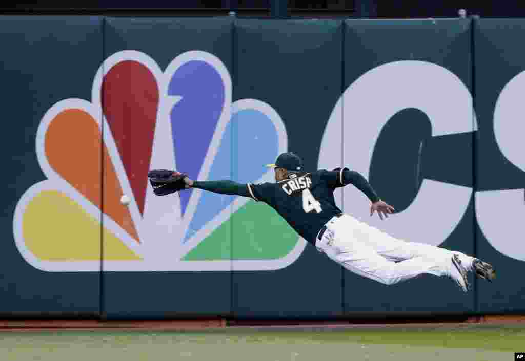 Pemain baseball Oakland Athletics, Coco Crisp gagal menangkap bola pukulan pemain Houston Astros, Luis Valbuena dalam pertandingan di Oakland, California.