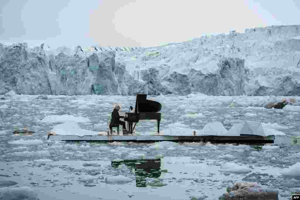Pianis Italia Ludovico Einaudi bermain piano di landasan yang mengambang di Samudra Arktik, Kutub Utara, dekat Ny-Alesund, Norwegia.