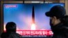 18일 한국 서울역 이용객들이 북한의 단거리 탄도 미사일과 대륙간탄도미사일(ICBM) 발사 관련 TV 뉴스를 시청하고 있다. 