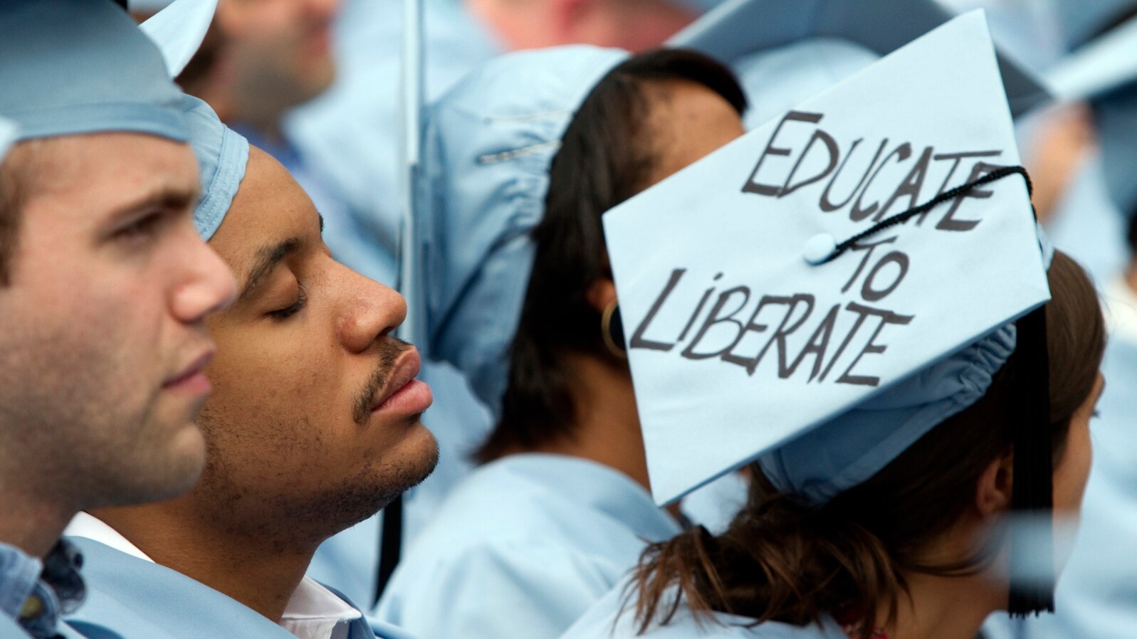 FILE - A graduate from Columbia University's School of Engineering sleeps during the university's commencement ceremony in New York, May 16, 2012.