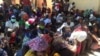 Deslocados, vítimas, da violência armada em Cabo Delgado aguardam na rua com as senhas para adquirir os seus produtos através da ajuda do PMA, em Pemba.