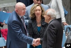 Ruski ambasador u Ujedinjenim nacijama, Vasilij Nebenzia, levo, pozdravlja se sa palestinskim ambasadorom u UN, Rijadom Mansurom, pre sastanka Saveta bezbednosti o situaciji između Izraelaca i Palestinaca, 1. juna 2018.
