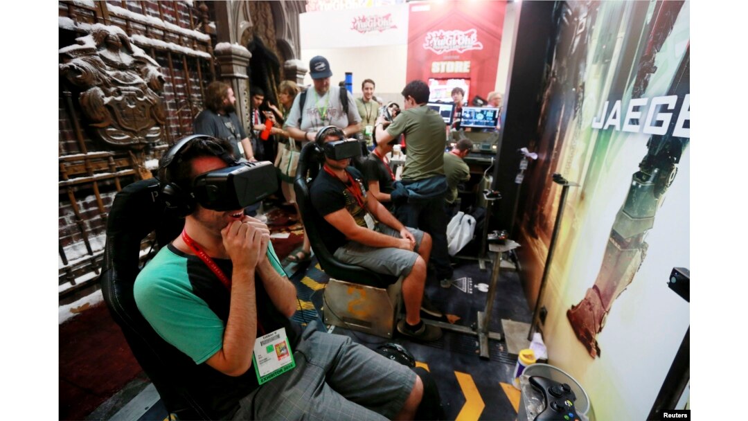 FILE - Attendees wearing Oculus Rift virtual reality headsets view a 3-dimensional video for the "Pacific Rim: Jaeger Pilot" video game during the 2014 Comic-Con International Convention in San Diego, California, July 25, 2014.