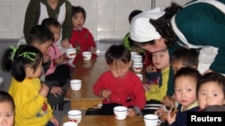 북한 룡천의 한 고아원에서 세계식량계획(WFP)이 제공한 옥수수-콩 혼합 간식을 먹는 어린이들.