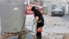 A Syrian refugee carries bread and bottles of water during a winter storm in Zahle town, in the Bekaa Valley, Dec. 11, 2013. 