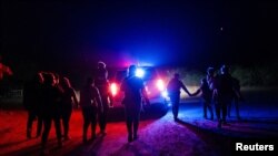 Personas en busca de asilo son escoltadas por autoridades estadounidenses tras cruzar el rio Grande desde México a la localidad de Roma, en Texas, en mayo de 2021.