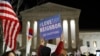 A protester carries a sign in front of the Supreme Court during a protest about President Donald Trump's recent executive orders, in Washington, D.C., Jan. 30, 2017.