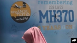 在馬來西亞吉隆坡舉行的MH370事件紀念日活動中，一名女孩站在哀悼留言板前。 (美聯社：2019年3月3日)